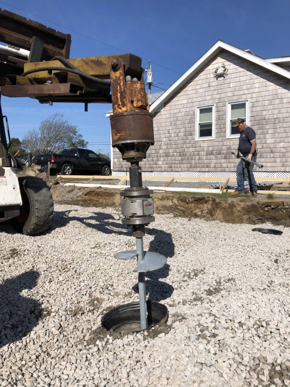 Installation of a helical pile foundation to support a reinforced concrete grade beam and structural columns for a coastal RI home